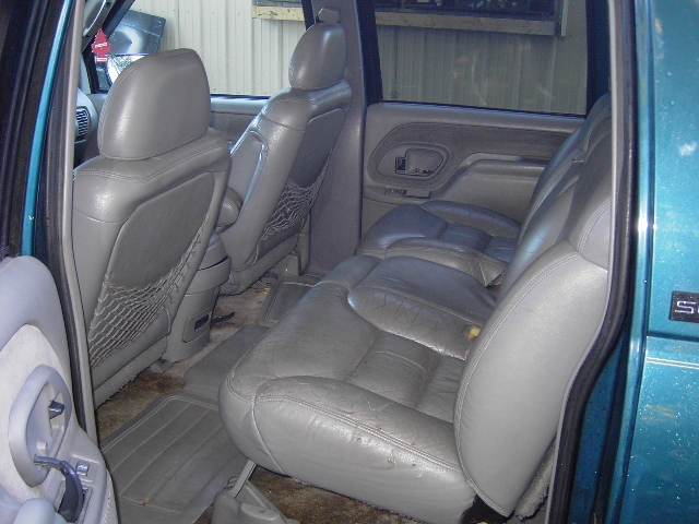 Gray leather second-row seats inside a teal GMC Suburban