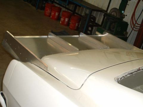 2005 Ford Mustang - A custom aluminum rear spoiler is installed on a white car, with a Supermotors.net logo visible.