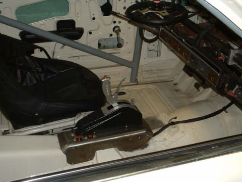 2005 Ford Mustang - The interior of a 2005 Ford Mustang, a racing seat, roll cage, and aftermarket shifter.