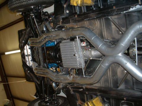 2005 Ford Mustang - The underside of a vehicle reveals a dual exhaust system and transmission components, with a SuperMotors.net watermark visible.