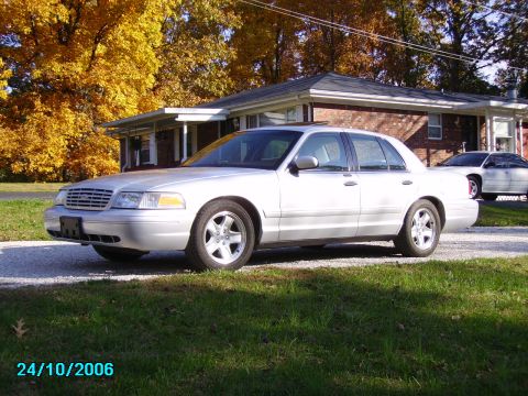 2002 Ford Crown Victoria - Silver 2002 Ford Crown Victoria parked outside a house during autumn.