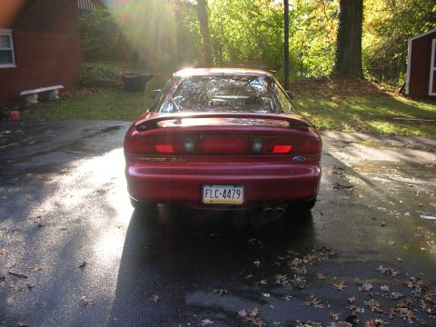 1995 Ford Probe - Rear view of a red 1995 Ford Probe, showing its distinctive taillights and spoiler.