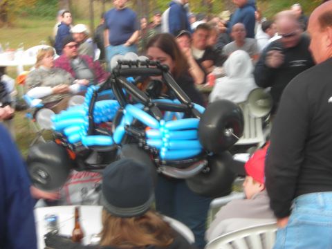 1997 Jeep TJ - A balloon sculpture of a go-kart is displayed at an outdoor gathering with many people present.