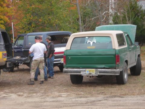 1997 Jeep TJ - This green SUV with a tan top is viewed from the rear, with a deer antler decal visible on the back window.