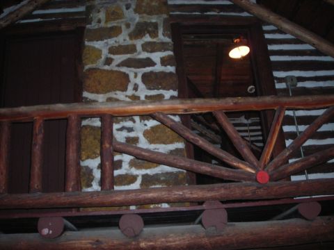 1997 Jeep TJ - Interior view of a rustic log cabin a stone fireplace and wooden railings.