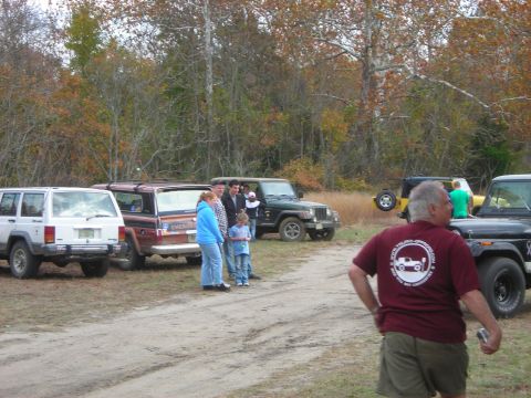 1997 Jeep TJ - Several Jeeps are gathered in a wooded area with people standing around them.