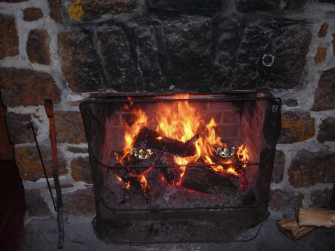 1997 Jeep TJ - A cozy fireplace crackles with burning logs, set against a stone hearth.