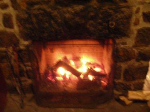 1997 Jeep TJ - A cozy fireplace crackles with warm flames, set against a rustic stone wall.