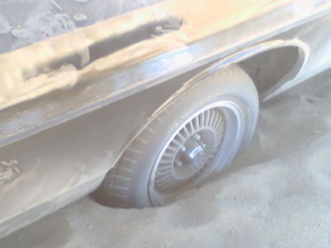 1972 Ford Ranchero - The rear wheel and fender of a 1972 Ford Ranchero are partially buried in sand.
