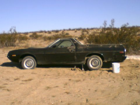 1972 Ford Ranchero - A black 1972 Ford Ranchero sits in a sandy, desert environment.