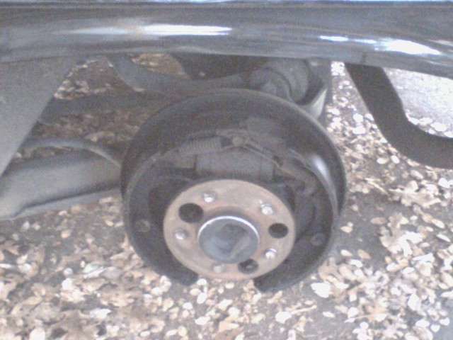 Close-up of a car's rear drum brake assembly with the wheel removed