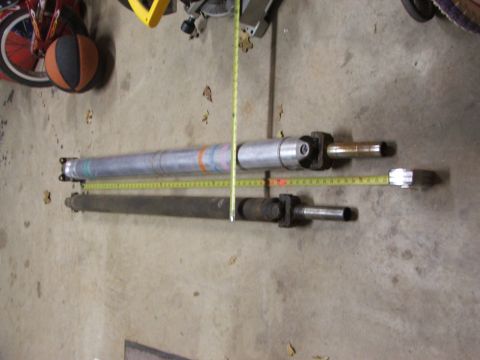 1965 Ford Mustang - Two driveshafts are measured on a concrete floor, with a basketball and part of a bicycle wheel visible in the background.
