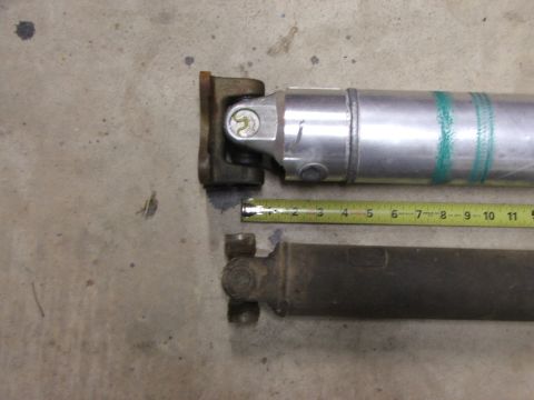 1965 Ford Mustang - Comparison of two driveshafts, one aluminum and one steel, with a tape measure indicating their lengths.