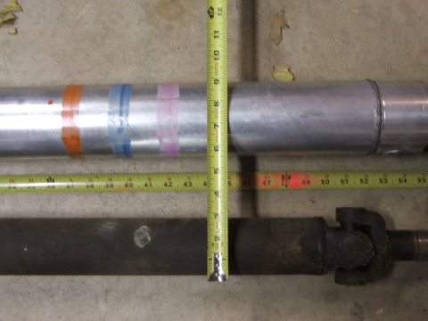 1965 Ford Mustang - Comparing two driveshafts using measuring tapes on a concrete floor.