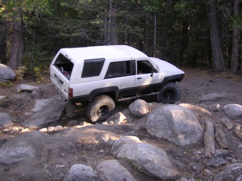 1985 Toyota 4Runner - 1985 Toyota 4Runner tackling difficult terrain on a forest trail.