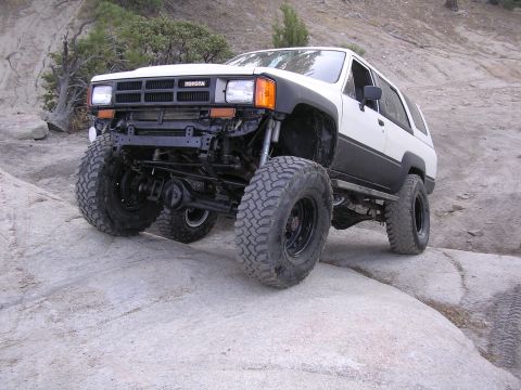 1985 Toyota 4Runner - This modified Toyota 4Runner is tackling a rocky trail with its large off-road tires and lifted suspension.