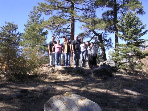 1985 Toyota 4Runner - A group of friends gathered on a rocky, wooded hillside under a bright blue sky.