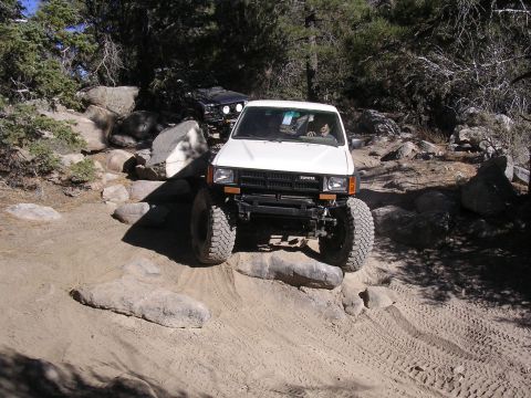 1985 Toyota 4Runner - A white 1985 Toyota 4Runner navigates a rocky off-road trail with a black SUV following behind.