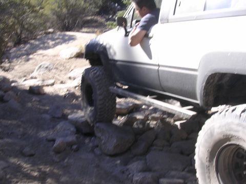 1985 Toyota 4Runner - A white Toyota 4Runner is shown off-roading on a rocky trail.