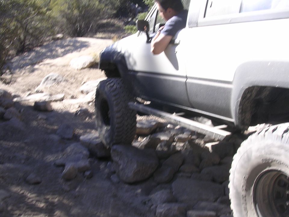 White Toyota 4Runner with large tires navigating rocky terrain