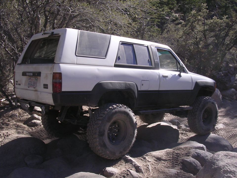 White 1985 Toyota 4Runner with camper shell on rocky trail