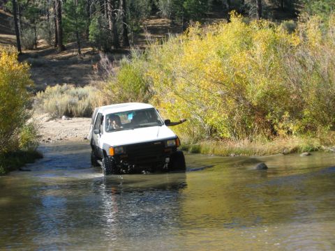 1985 Ford Bronco - White Toyota 4Runner navigating a stream during an off-road excursion.