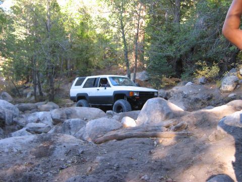 1985 Ford Bronco - This SUV is off-roading on a challenging rocky path.