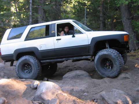 1985 Ford Bronco - Modified Toyota 4Runner navigating a challenging off-road course in a wooded area.