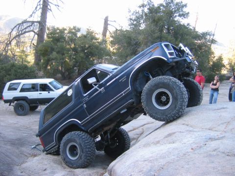 1985 Ford Bronco - A modified 1985 Ford Bronco navigates a rocky trail, demonstrating its off-road capabilities.