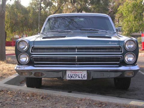 1975 Ford Ranchero - Teal 1966 Mercury Comet parked outdoors, showing its distinctive front grille and headlights.
