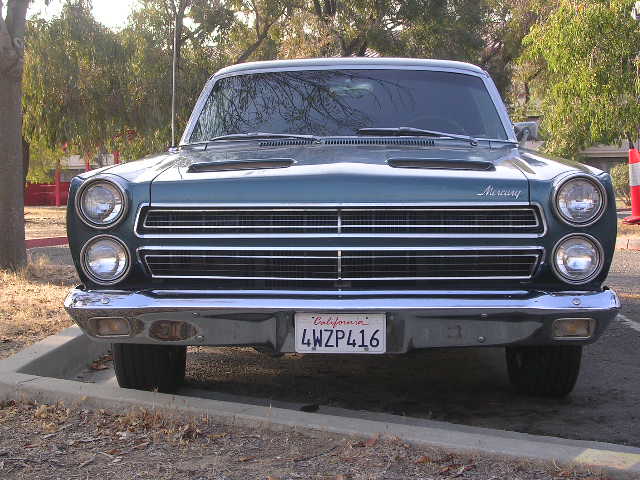 Front view of a teal 1966 Mercury Comet with a chrome grille and California license plate 4WZP416