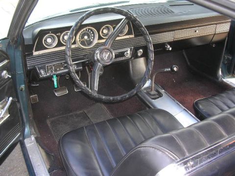 1975 Ford Ranchero - Interior view of a classic car, black vinyl seats and a dashboard with multiple gauges.