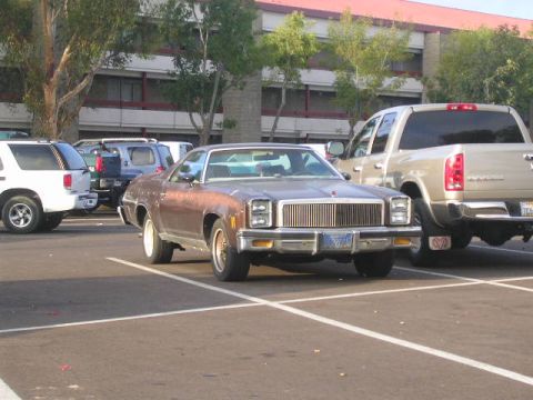 1975 Ford Ranchero - A 1975 Ford Ranchero is parked in a lot, showing its distinctive chrome grille and front end.