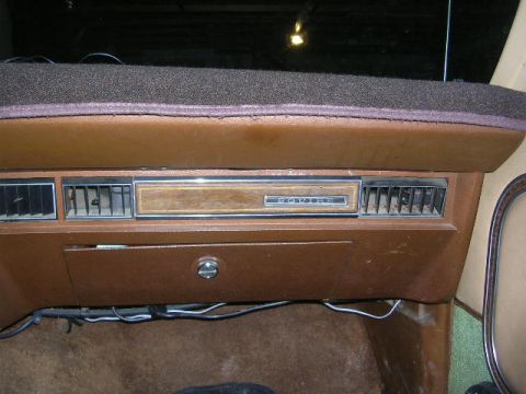 1975 Ford Ranchero - Close-up of a car's dashboard, showing air vents and a central wood-grain trim piece.