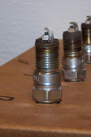 2000 Ford Crown Victoria - Close-up of several used spark plugs, with one in focus showing electrode wear.