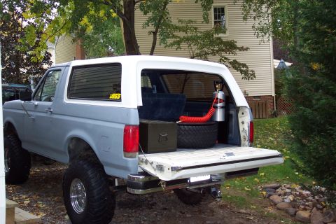 1987 Ford Bronco - 1987 Ford Bronco with spare tire, toolbox, and CO2 tank visible in the cargo area.