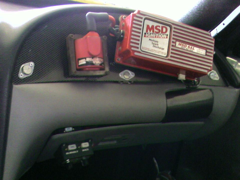 Red MSD 6AL ignition box and coil mounted on a gray dash inside a car
