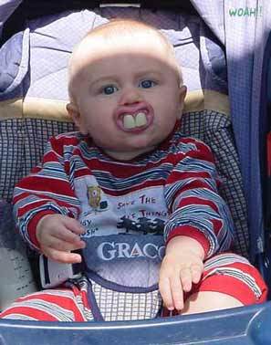 1986 Ford Bronco - A baby with oversized fake teeth sits in a stroller, looking directly at the camera.