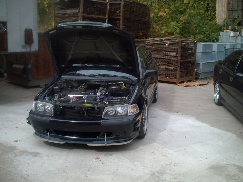 2006 Volkswagen GTI - A black car with its hood open, revealing the engine bay, parked outdoors. Another vehicle is partially visible on the right side.