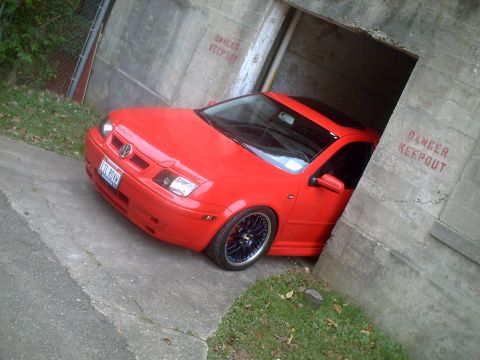 2006 Volkswagen GTI - A red Volkswagen sedan is partially backed into a concrete structure with 'DANGER KEEP OUT' stenciled on the walls.