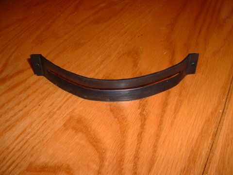 1978 Ford Mustang II - A black rubber trim piece with a red accent strip is shown on a wooden background.