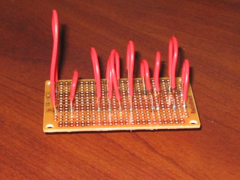 1991 Ford Bronco - A circuit board with red wires is shown on a wooden surface.