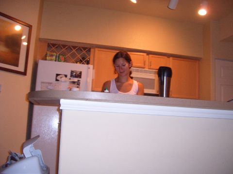 1988 Ford Bronco - A woman stands in a kitchen area, with a refrigerator and cabinets visible behind her.