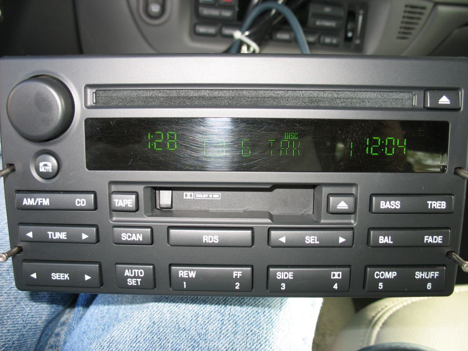 Car stereo with CD player, tape deck, and green digital display