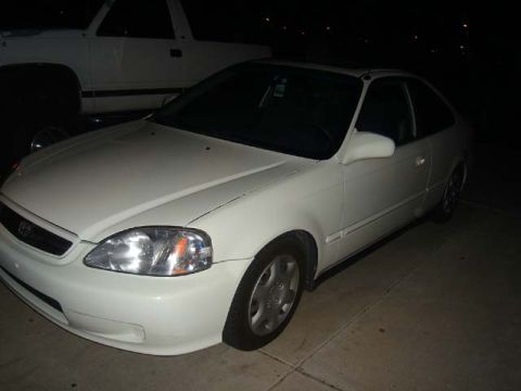 1997 Ford Probe - A white coupe is parked next to a white pickup truck at night.