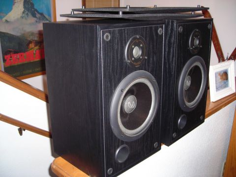 2003 Jeep TJ - Two black Infinity bookshelf speakers are positioned on a wooden railing, with a framed picture in the background.