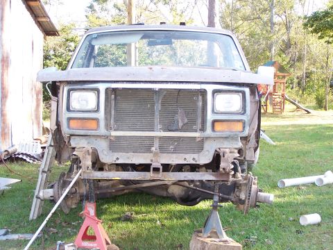 1981 Ford Bronco - Front view of a 1980 Ford Bronco undergoing repairs, missing its grille and front wheels.