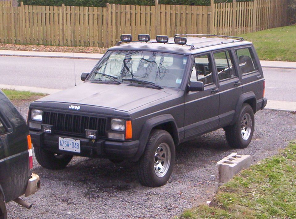 1990 Jeep Cherokee SUV parked on gravel, front quarter view