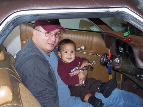 1973 Ford Ranchero - A man and a baby sit inside the interior of a 1973 Ford Ranchero.