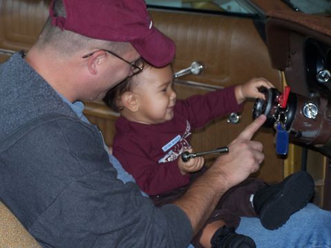 1973 Ford Ranchero - Father and child explore the interior of a 1973 Ford Ranchero, with the child holding a wrench near the steering wheel.